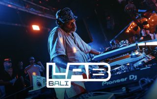 DJ wearing a helmet/hat blends tracks at a club; LAB Bali logo overlays the scene with Pioneer DJ gear visible in the foreground.